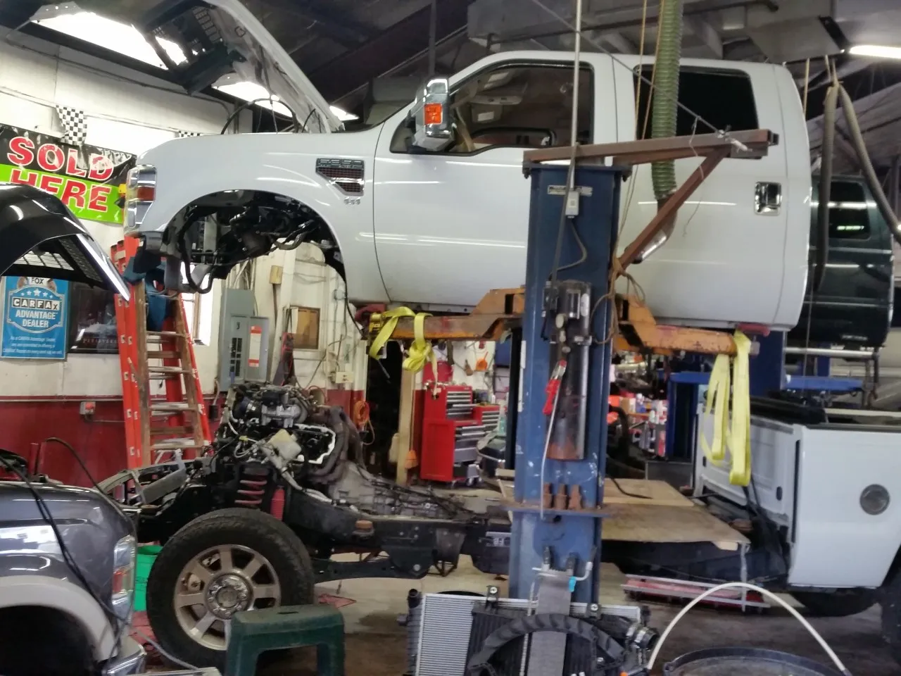 A white truck on a lift in ATR's working repair bay